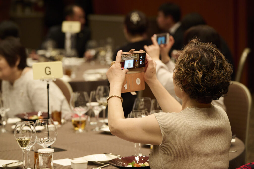 映像に懐かしいOB社員たちがサプライズ登場し、思わずカメラを構える女性たち