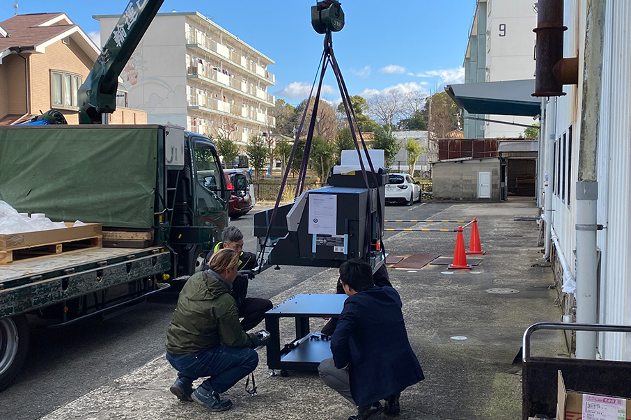 クレーンでトラックから積み降ろされるUVプリンター