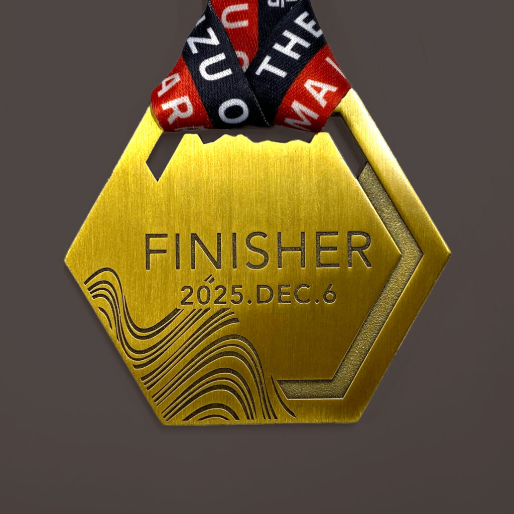 伊豆大島マラソンメダルの裏面。FINISHERの文字と地層断面がデザインされている。